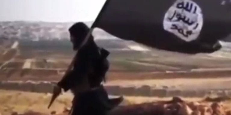 ISIS - a terrorist carrying the organization's flag.