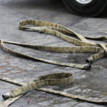 Fire Hoses next to a Fire Engine, waiting to be stored back on the truck.